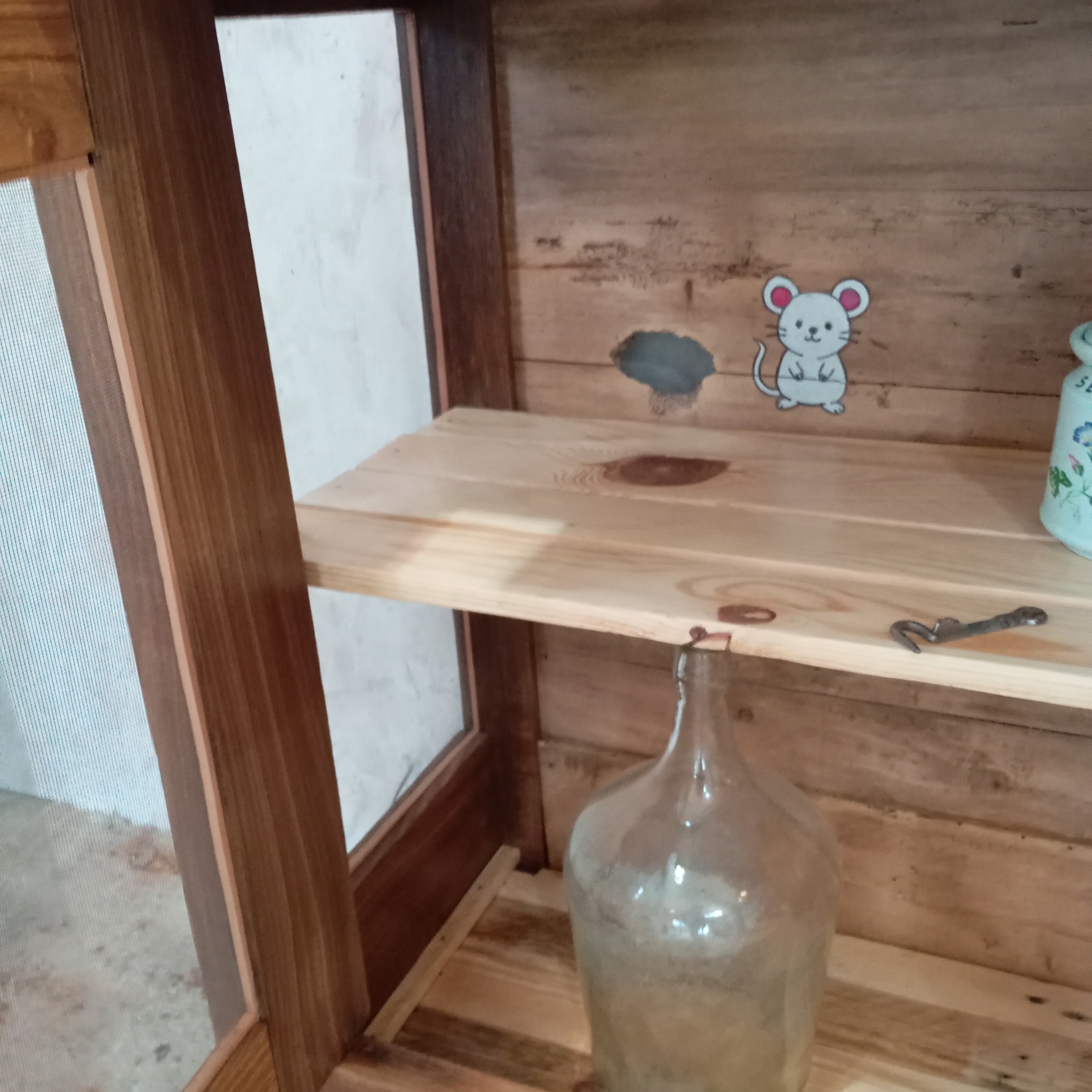 buffet en châtaignier transformé en garde manger vue de l'intérieur droit. Zoom sur une souris dessinée et son trou